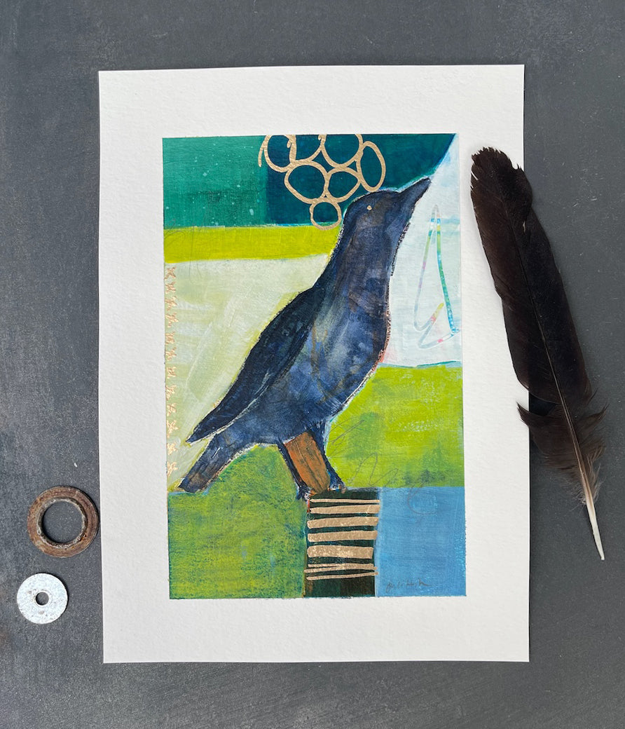 Flat lay crow painting with feather and shiny objects