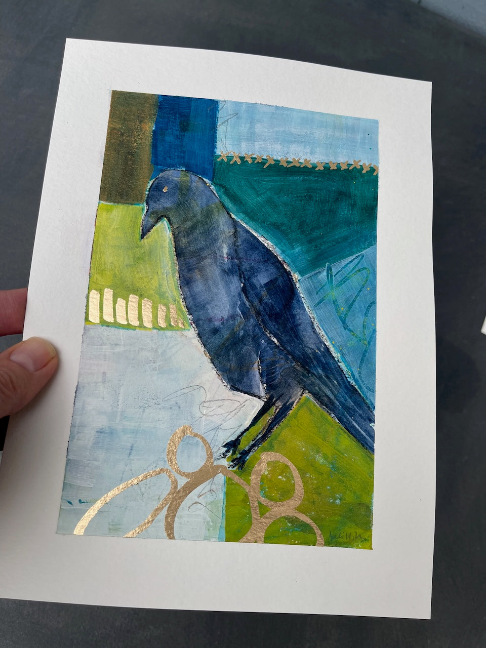 hand-held crow painting to show the glimmer of gold marker embellishments