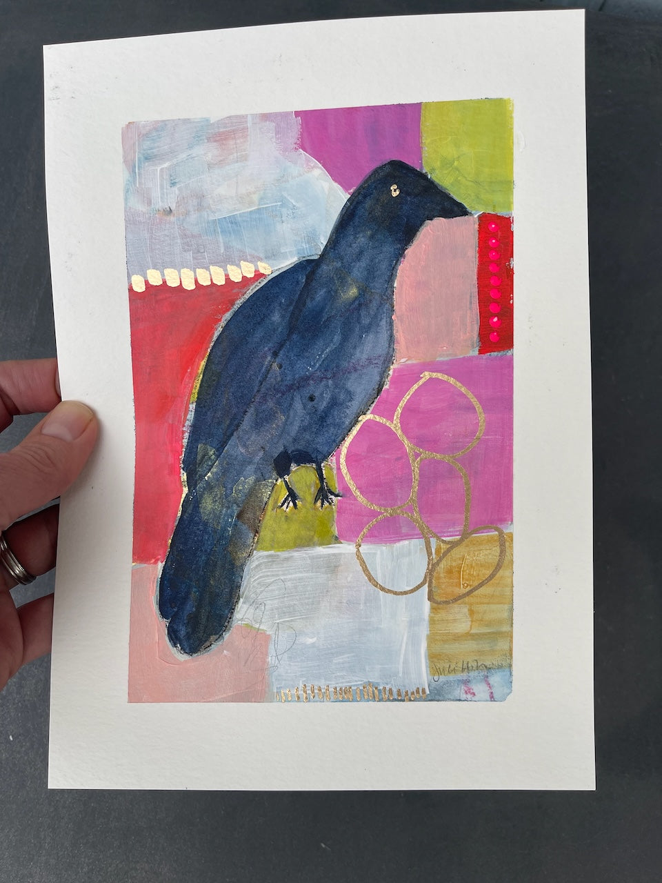 hand-held crow painting to show the glint of gold in the metallic pen embellishments