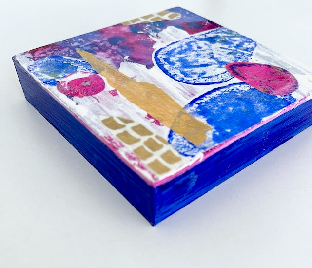 side view of mini collage art panel in purple, white and magenta with painted cobalt blue edges