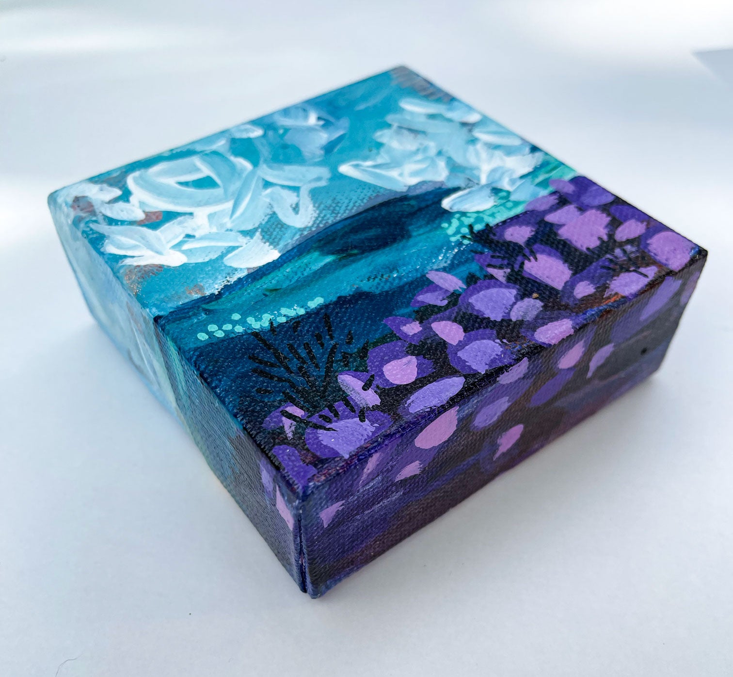 side view of mini abstract landscape painting in purple and teal showing painted wrap around edges