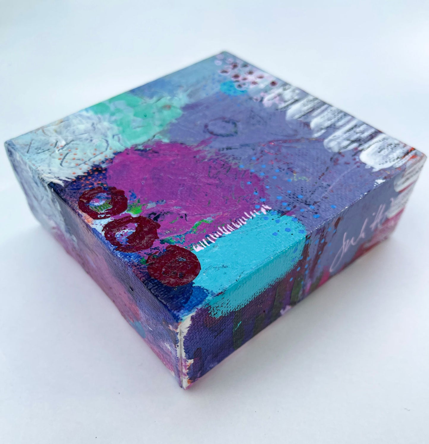 side view of purple blue and teal mini art canvas painting showing the painted wrap around edges